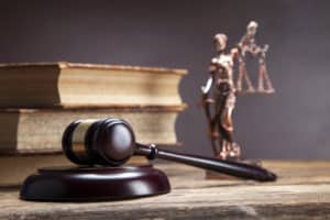 Criminal Justice degree books, gavel and Lady Justice statue