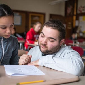 Zackary Petker, Saint Rose Alumni, helping student in his classroom