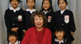 Toshiko Tanaka, Saint Rose Class of 1963, posing with children at her school in Japan, where she is vice principal