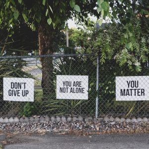 signs that say don't give up, you are not alone, and you matter